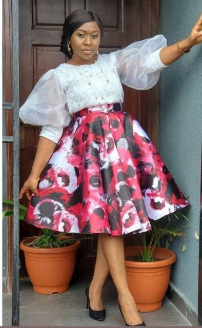 An Ankara wrap skirt with a white blouse and a statement necklace