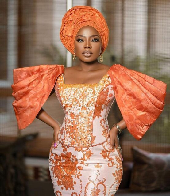Woman in elegant orange traditional attire.