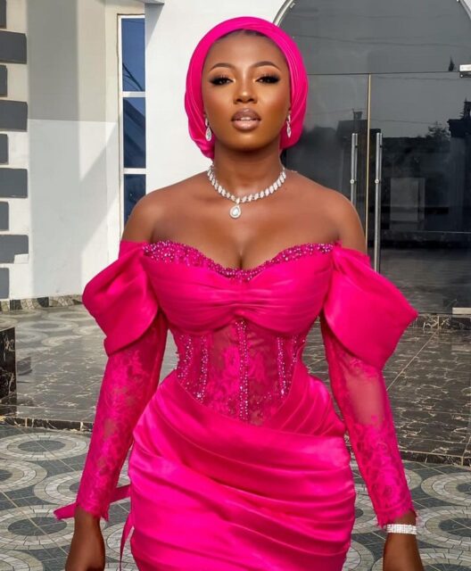 Woman in elegant pink dress and headscarf.