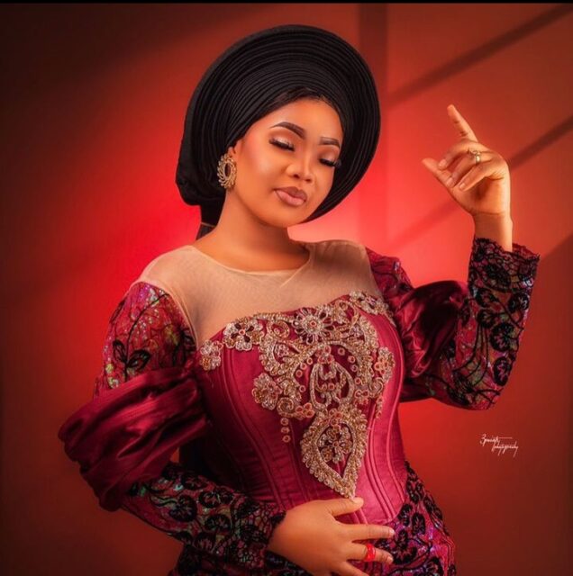 Woman in traditional African attire posing elegantly.