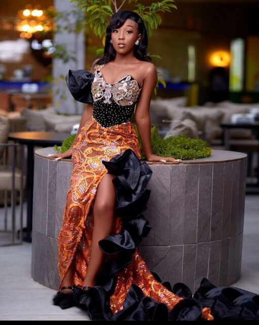 Woman in elegant African-inspired evening gown posing.