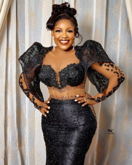 Woman in elegant black sequin dress smiling.